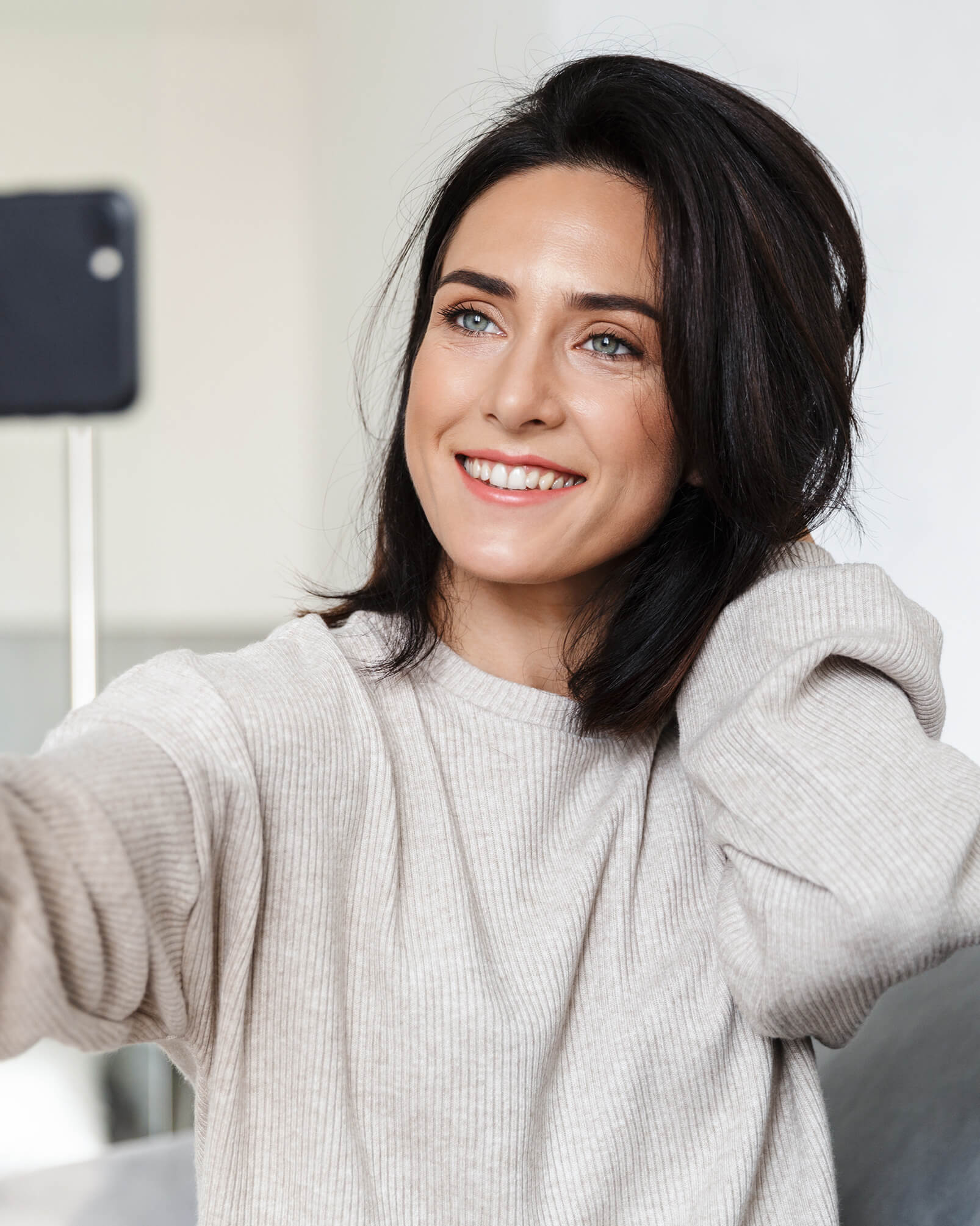 Woman s taking selfie on cell phone while sitting on couch