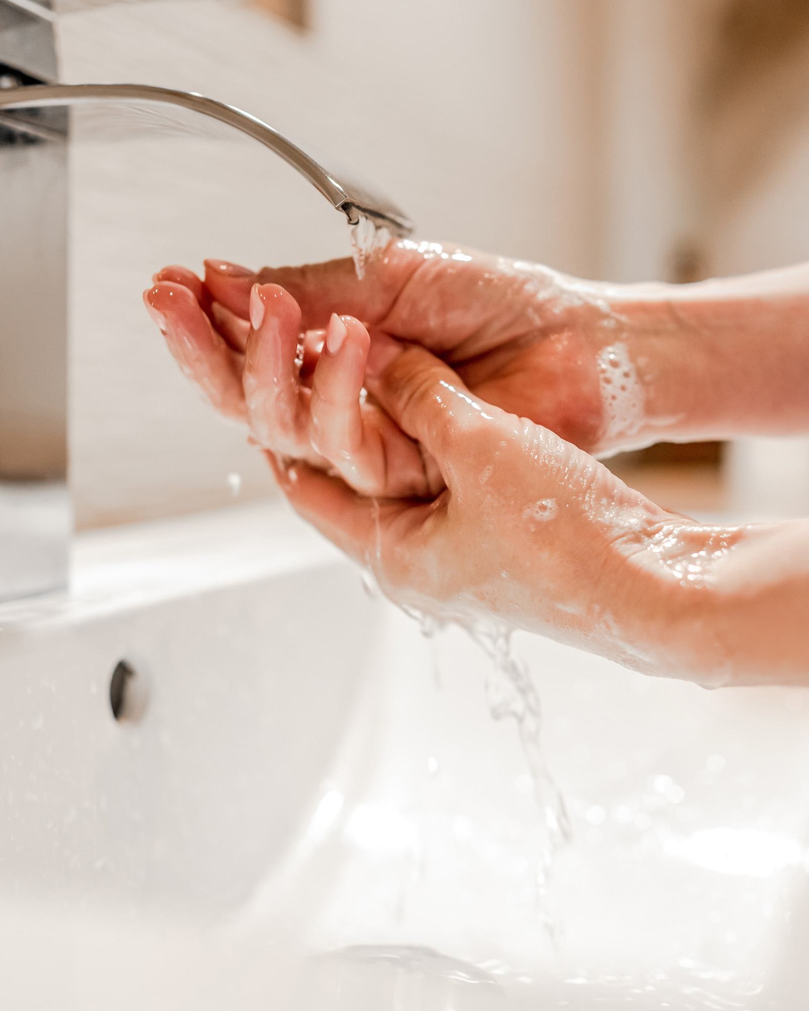 a person washing her hands in the sink